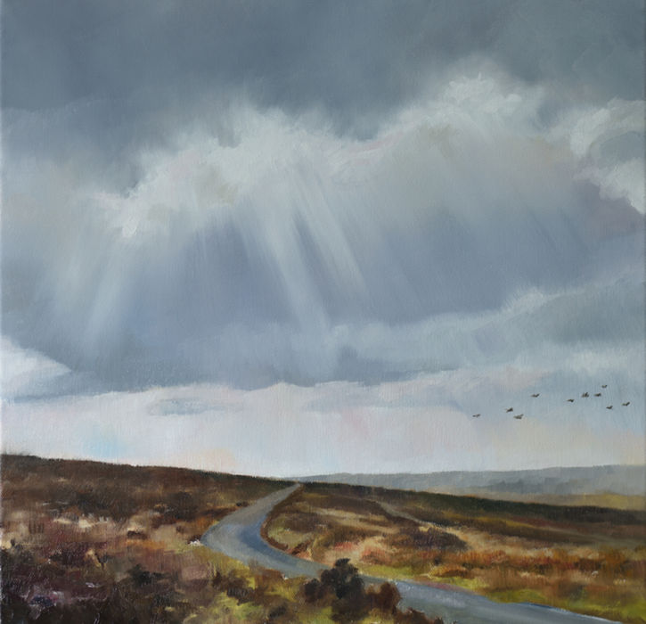 Moorland road with dramatic skies beyond