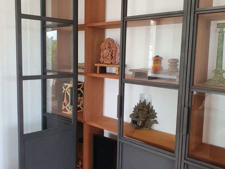 Beautifull solid iroko kambala wooden shelving perfectly fit this space, finished by modern steel and glass doors
