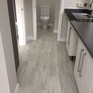 Modern interior showing a sleek kitchen with grey flooring