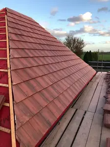 A newly constructed sloped roof with red tiles