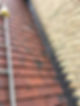 A steep outdoor staircase with red steps, bordered by a yellow brick wall on one side