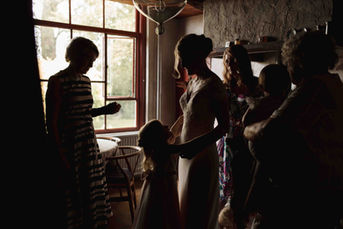 Familie rondom bruid met aantrekken trouwjurk