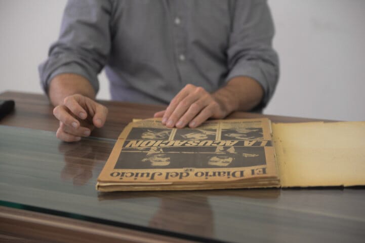 Mão esquerda de Gonzalo sobre a capa do jornal "El Diario del Juicio" 