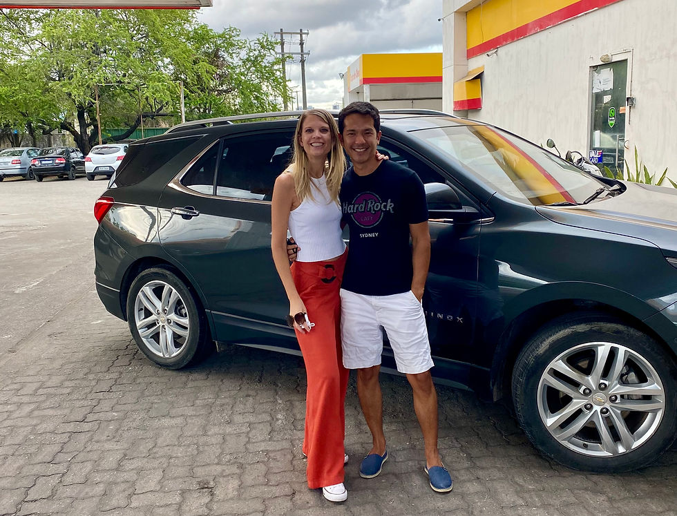 This image is of Philippa and Vitor in front of a black chevy equinox they have named "REX." The caption reads: Ready to Road Trip." The Great Brazilian Road Trip is ready to begin!