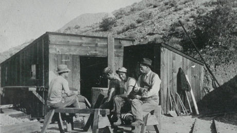 Miners taking a break from work just outside of an entrance into the Tropico Gold Mine (c. 1912)