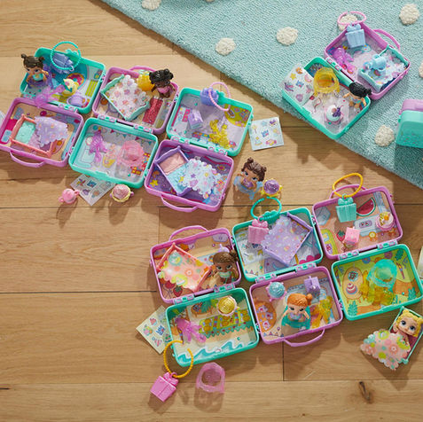 Baby Alive Foodie Cuties toy product flat lay with colorful accessories on bright clean surface