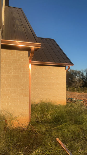 sparkling copper gutters on  brick home