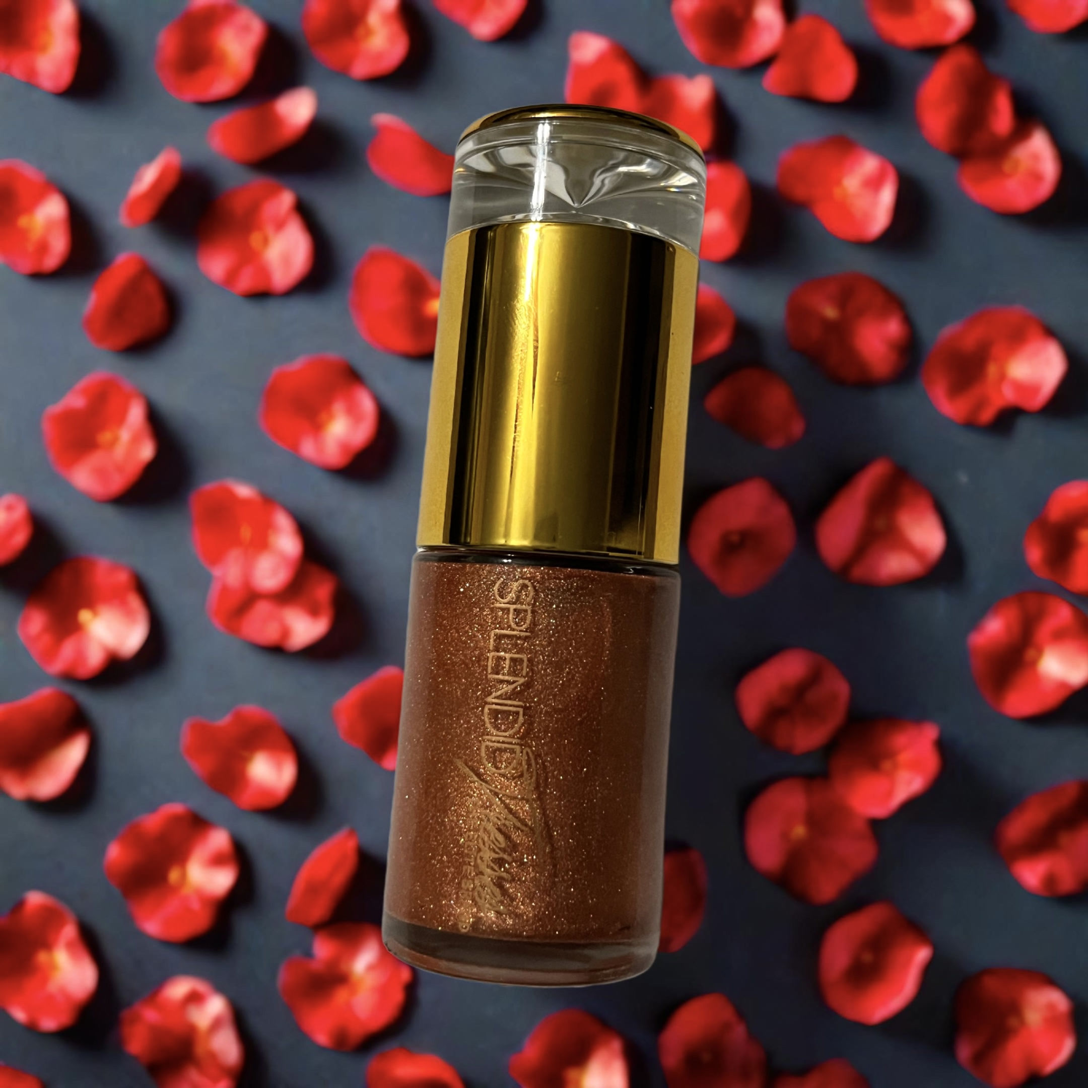 Splendid Tresses Glistening Glow Oil, set against a background of vibrant red rose petals.