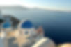 Blue-domed churches overlook the Aegean Sea in Santorini, Greece