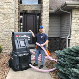 Joshua standing next to the insulation machine. 