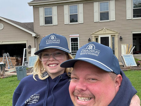 Jeremy and his kid in front of a house getting new Duncan's windows