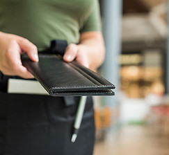 Restaurant-Server-with-Customer-Bill-1169593492.jpg