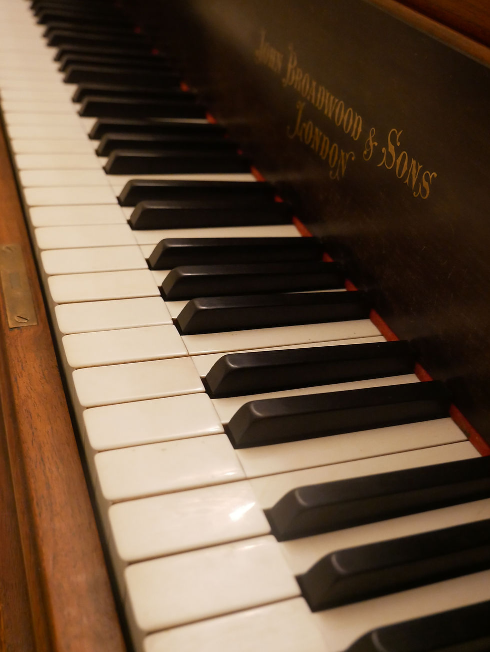 Close-up of the keys and nameplate of a John Broadwood & Sons grand piano.