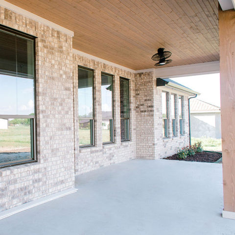 The back patio at our Fresh Farmhouse is a clean and expansive space lined with large windows for clear sightlines.