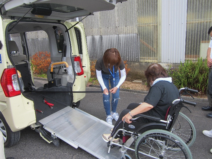 車椅子で介護ケアの車へ乗る女性