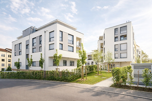 Moderne Wohnanlagen in grüner Umgebung.png