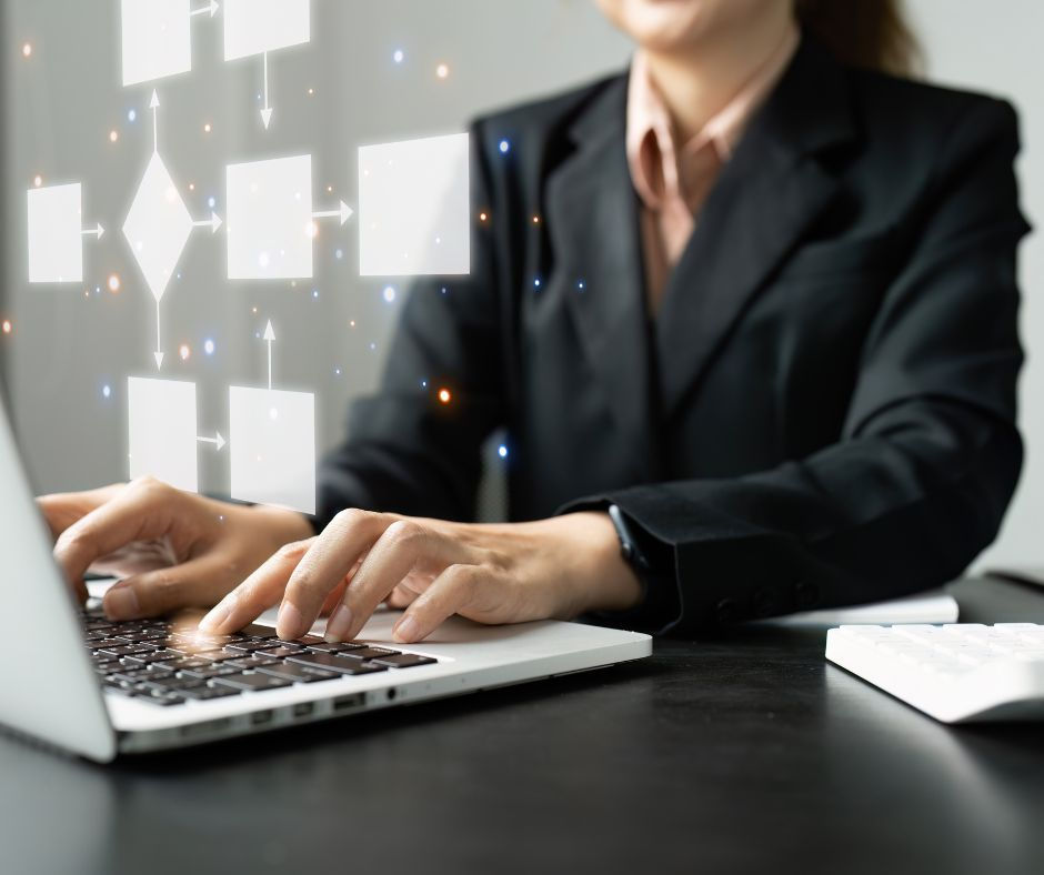 A woman sits at a laptop with an superimposed image of a process map hovering in front of her