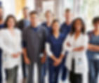 a group of nine hospital workers stand smiling