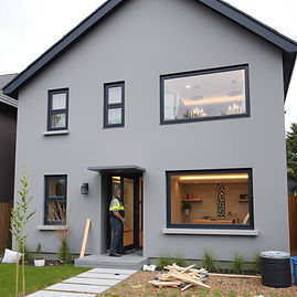 A grey modern house with a builder working.jpg
