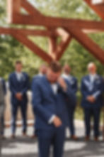 groom standing under beautiful timber frame arch at Fayette County, WV wedding venue, photo taken by