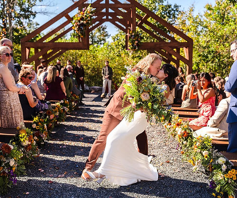 Bride and Groom kissing in front of arch.