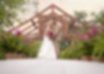 Beautiful outdoor wedding ceremony with couple surrounded by ferns and pink flowers during June wedd