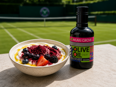 A bowl of yoghurt topped with berry powder, kiwi, granola, and early harvest high-phenolic extra virgin olive oil.