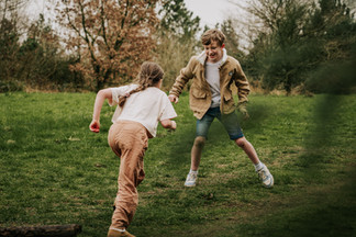 Sibling play and movement during a natural family photoshoot in Cheshire.