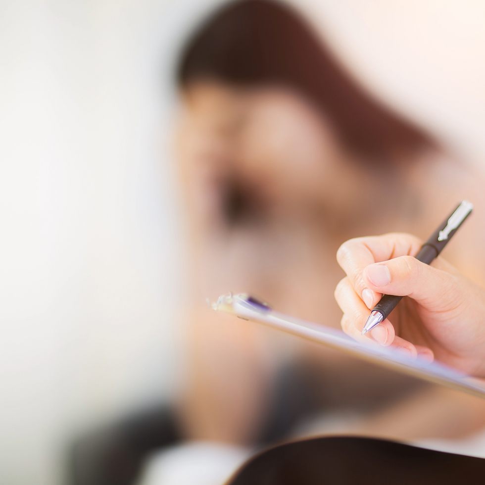 Therapist taking notes during a consultation with a distressed client