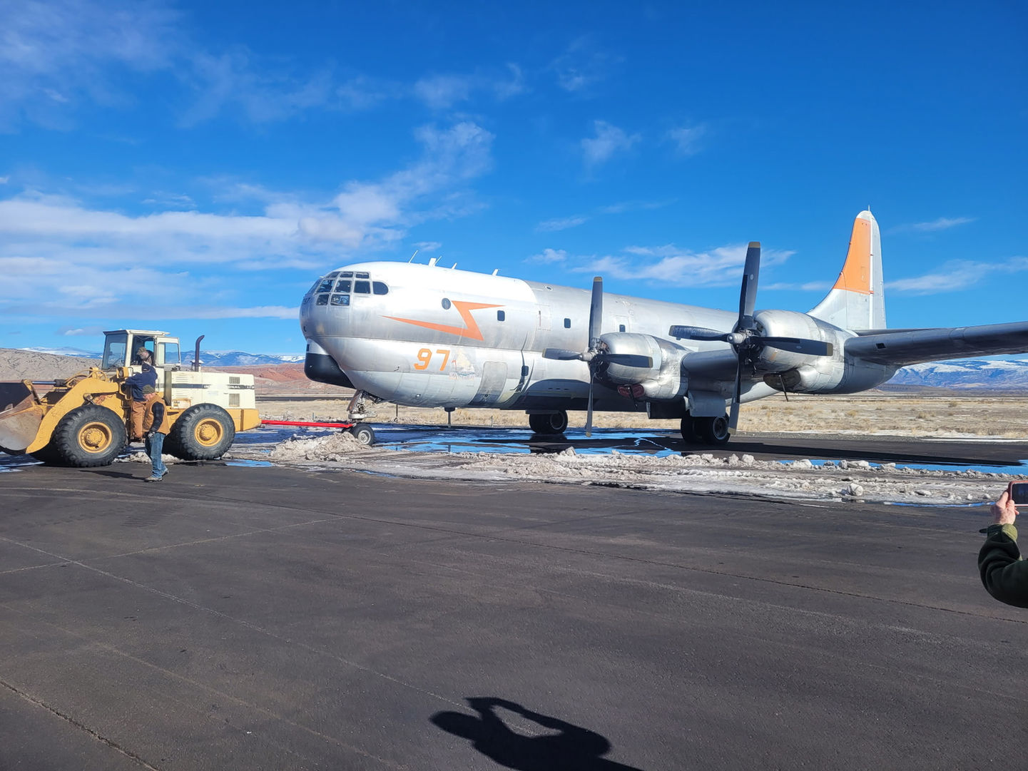 Blue skies reflect off the aluminum of the 97 as a tractor begins the journey of hauling it off the runway of the airport in Greybull, Wyoming.