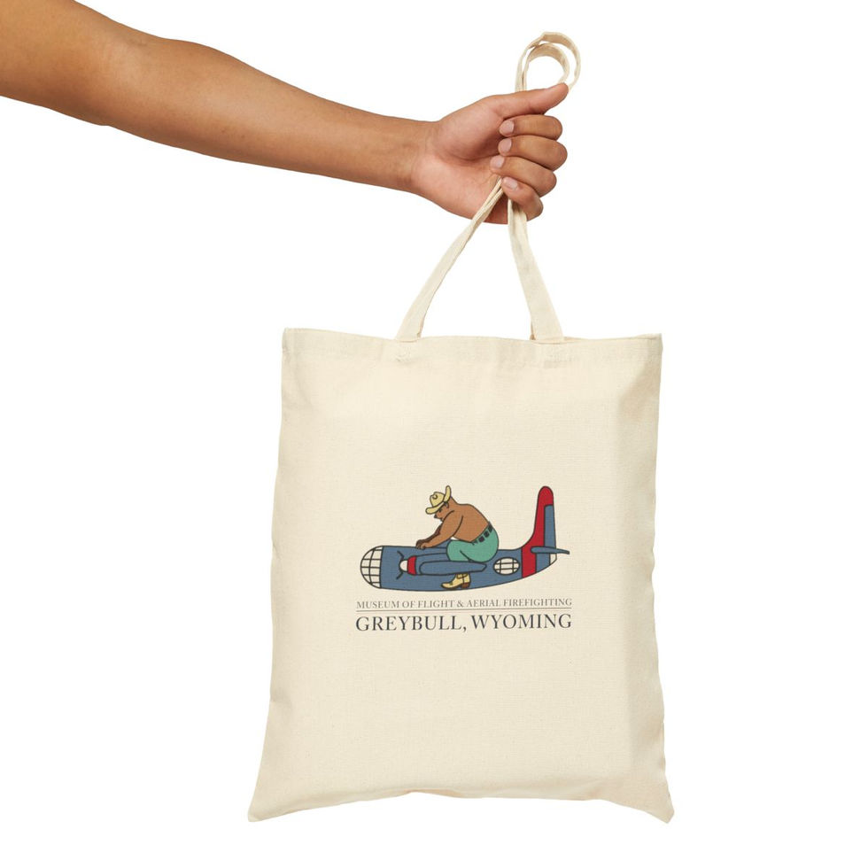 Person holding Greybull, Wyoming tote bag featuring plane illustration