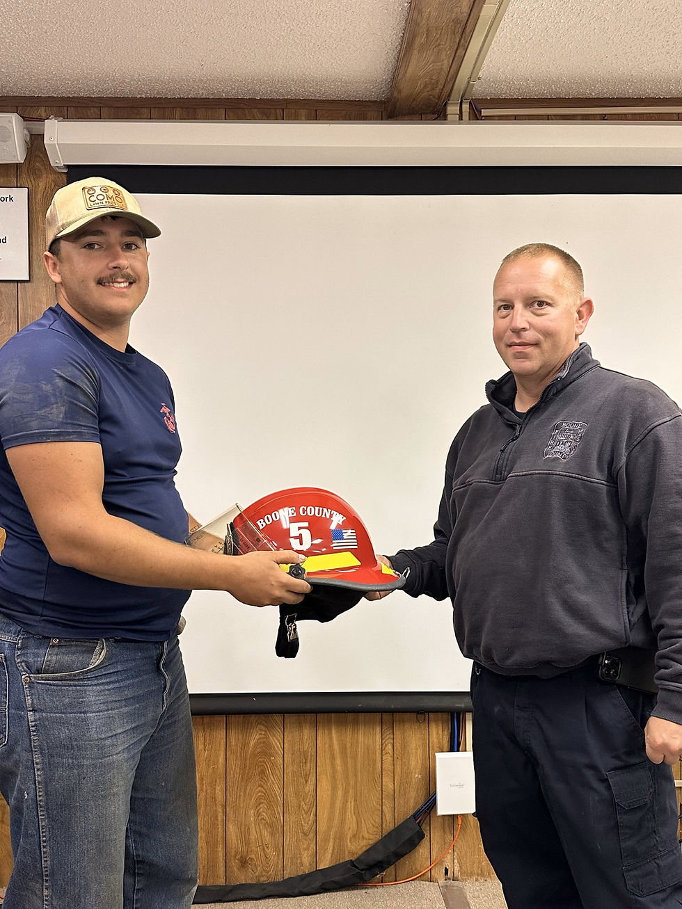 Firefighter-EMT Caleb Bogus receiving red helmet