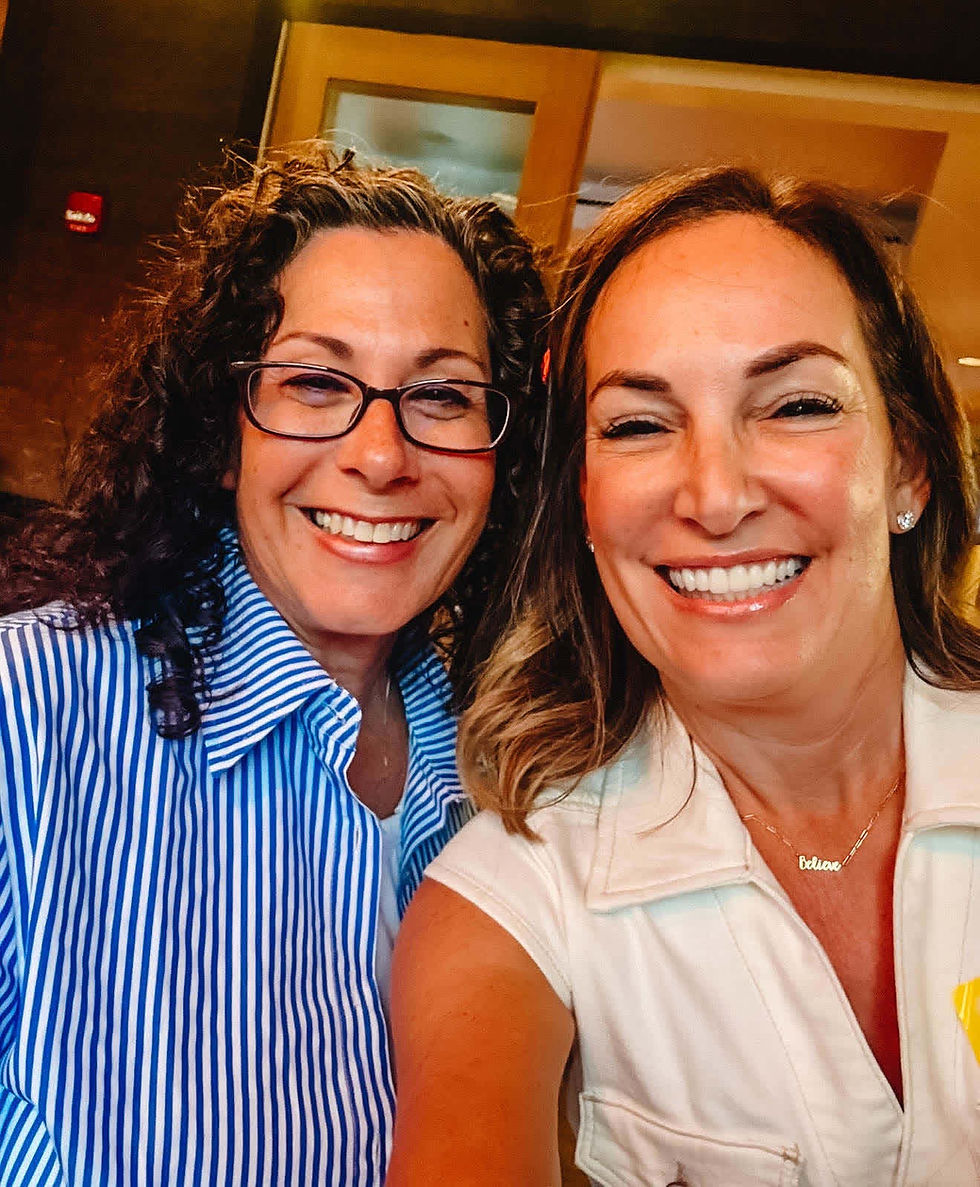 Dana and Alison smiling together at dinner.