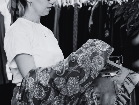 Woman holding clothing and shopping secondhand.