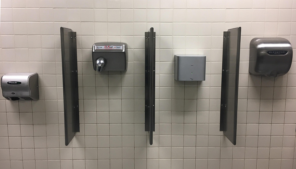 Various hand dryers on a bathroom wall