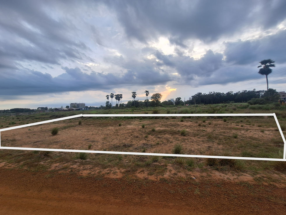 Open field with white lines, cloudy sky, and a distant building. ApnaJagah