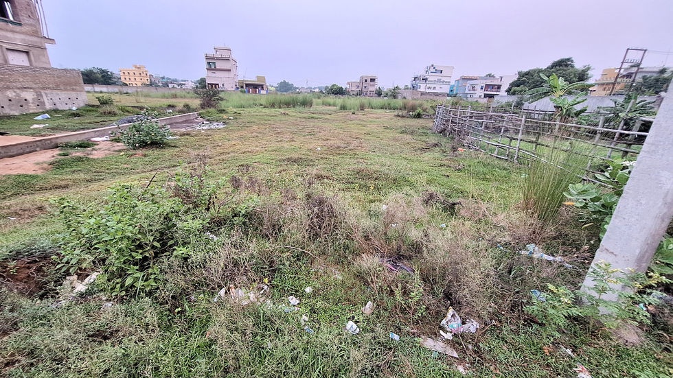 Open land, grass, and buildings in the background, a cloudy sky ApnaJagah.
