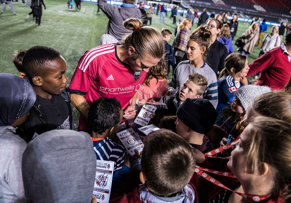Lance signing autographs after soccer game