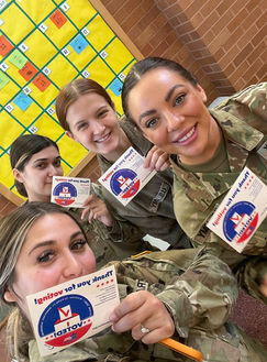 Soldiers holding up voting information cards.