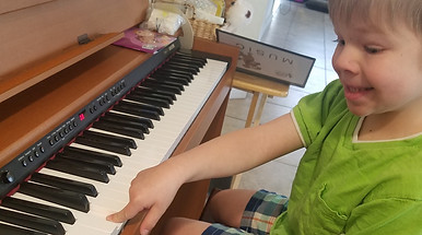 young child playing the piano with one finger