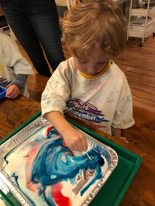child painting with a stick cks