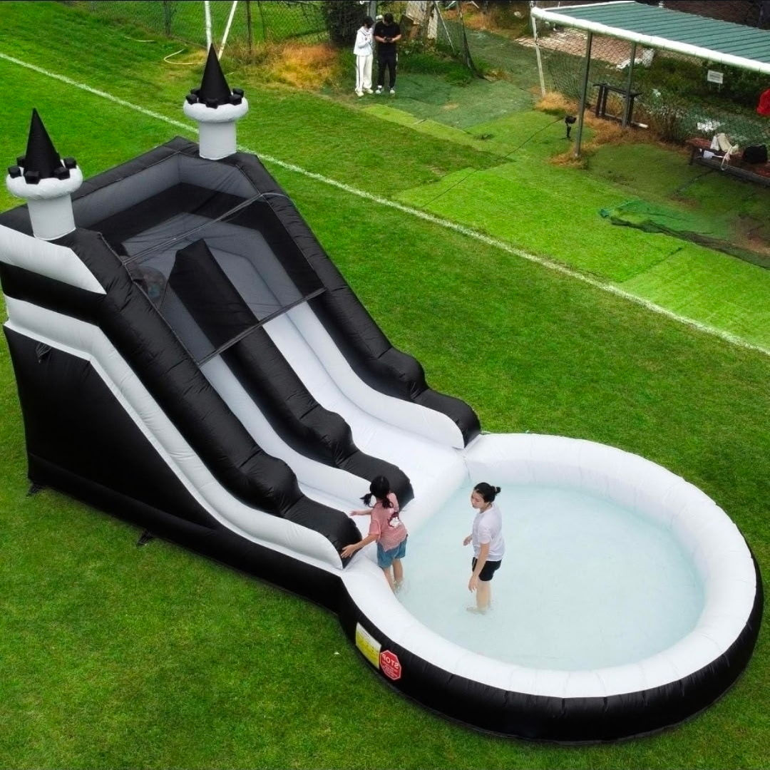 Large black and white marble inflatable water slide with a steep curved drop and refreshing splash pool.