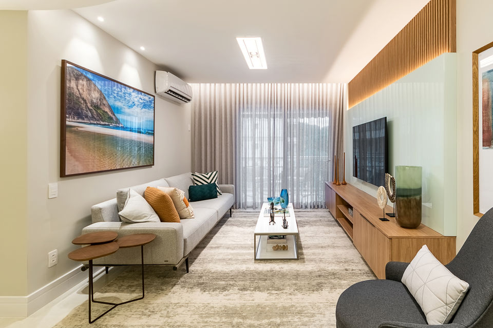 Sala de estar contemporânea com sofá claro, mesa de centro moderna e painel de madeira com iluminação embutida. Ambiente clean e aconchegante, com cortinas de linho, tapete neutro e composição elegante de almofadas. Projeto de interiores de alto padrão com elementos de design minimalista e iluminação indireta.