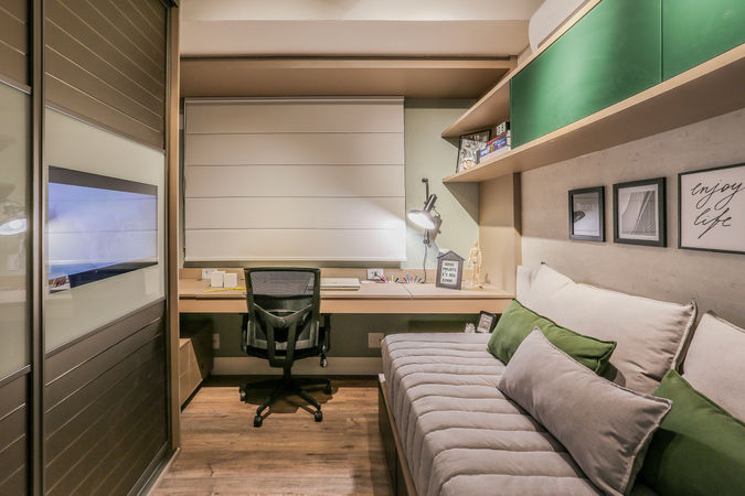 Quarto multifuncional com cama tipo daybed, armários verdes, bancada de estudos e marcenaria planejada. Espaço versátil e jovem com design funcional e acolhedor.