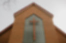 View of the outside of the Fellowship Hall at Calvin Church, which includes a cross over a large glass block window