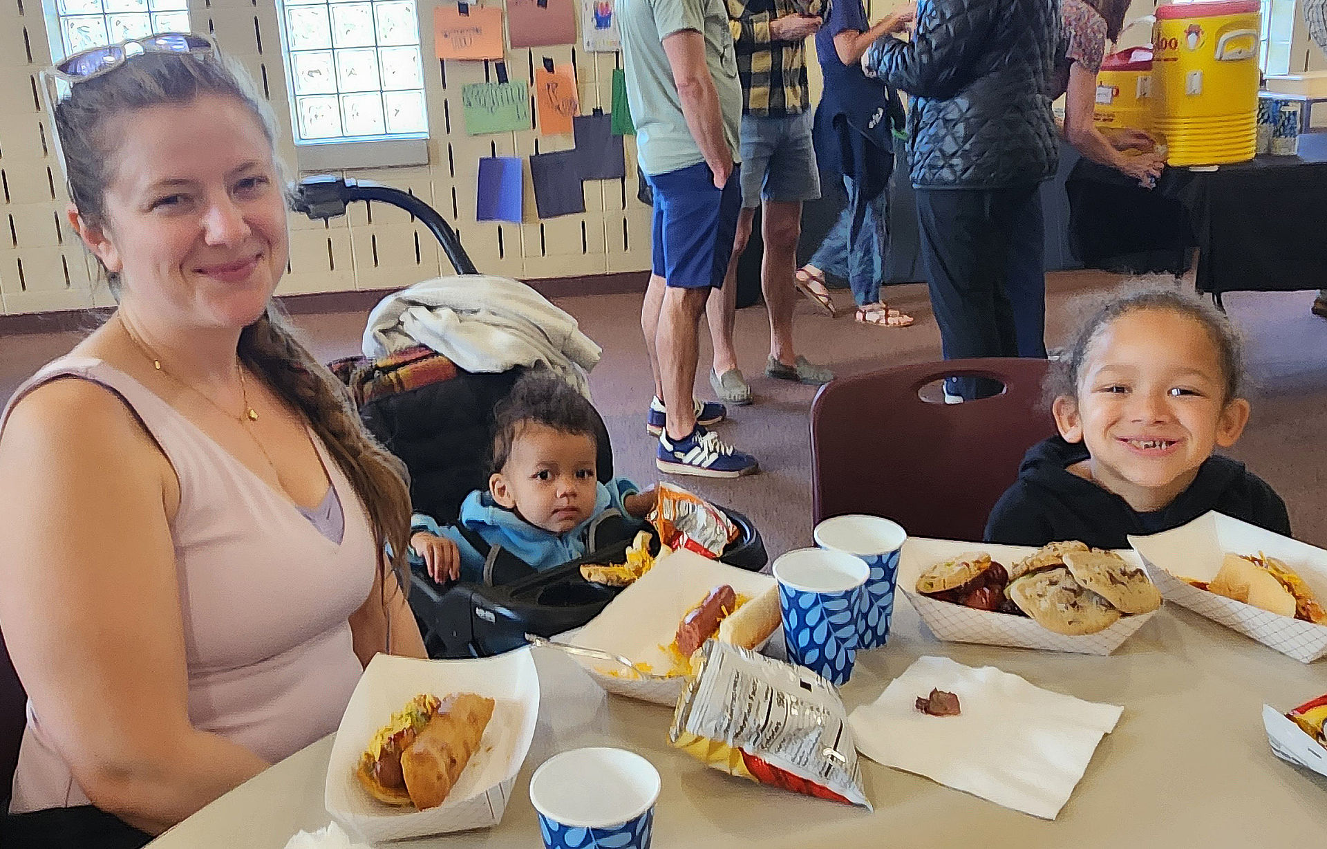 Family enjoying hot dogs and other food during the Calvin Church community event