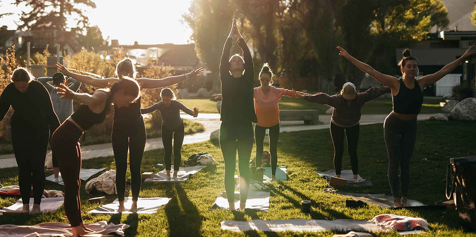 A group of energised individuals embrace the sun and their daily yoga session
