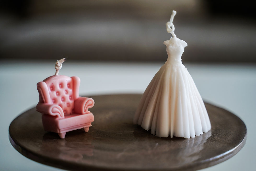 נר בצורת שמלת כלה ולידו נר בצורת כורסה ורודה