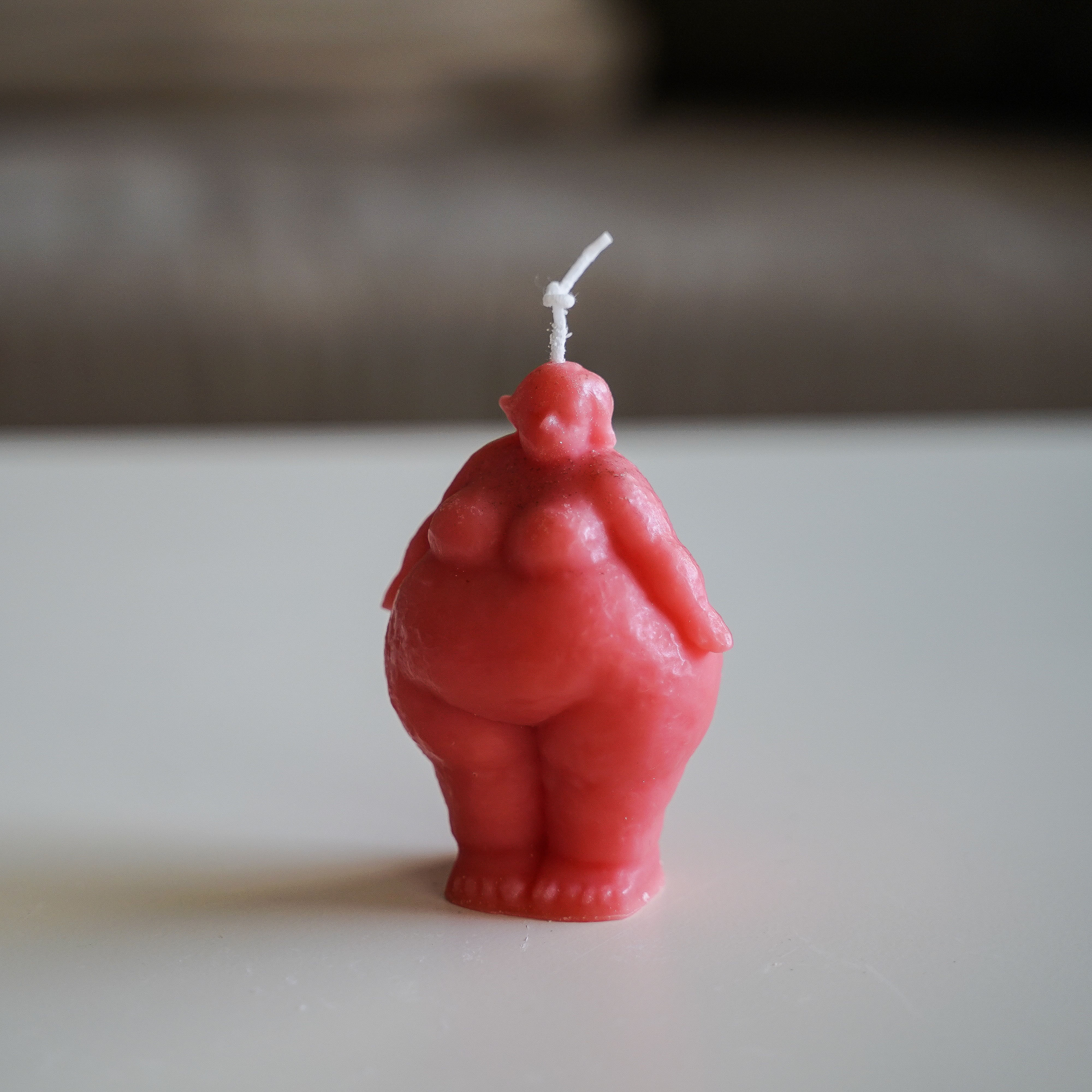 נר אדום בצורת אישה שמנה שעומדת
