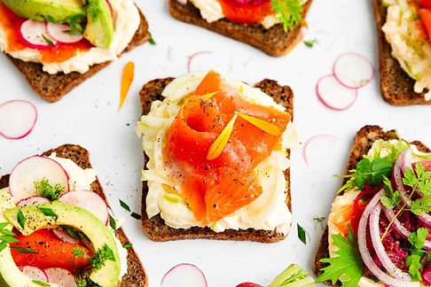 Beautifully styled colourful sandwiches laid out on a plain surface